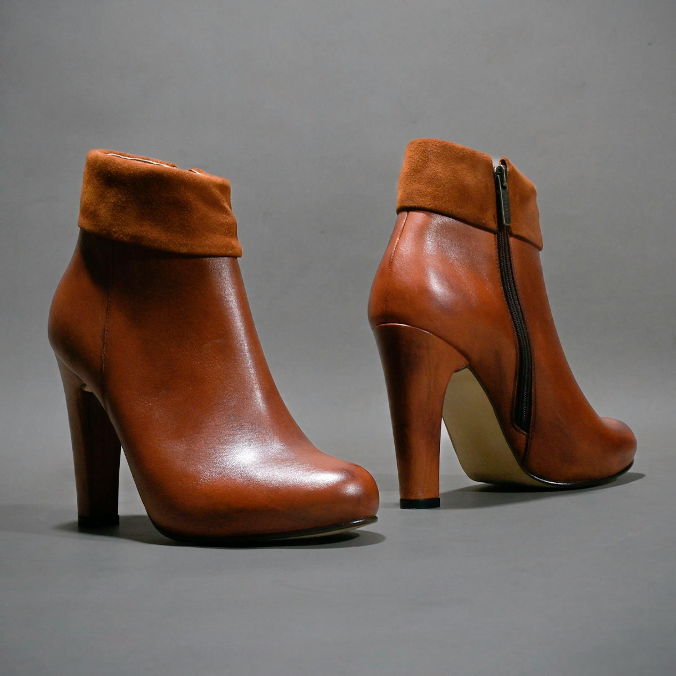 Pair of stylish brown leather high heel boots with suede trim, perfect for fashion lovers.